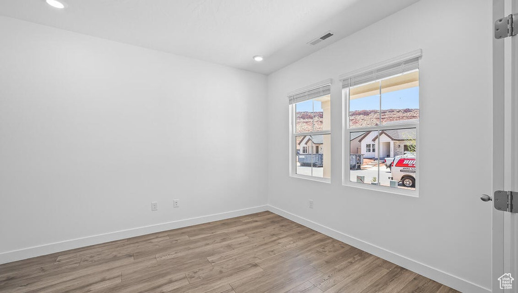 Unfurnished room with wood finished floors and recessed lighting