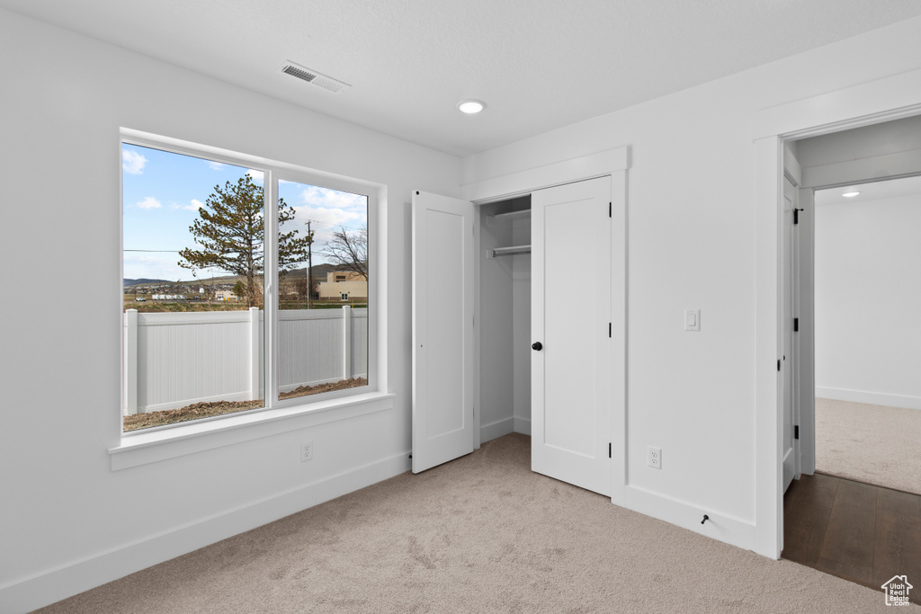 Unfurnished bedroom featuring carpet flooring, recessed lighting, and a closet