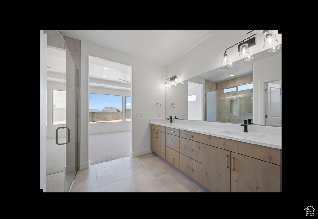 Bathroom featuring double vanity, a stall shower, and tile patterned flooring