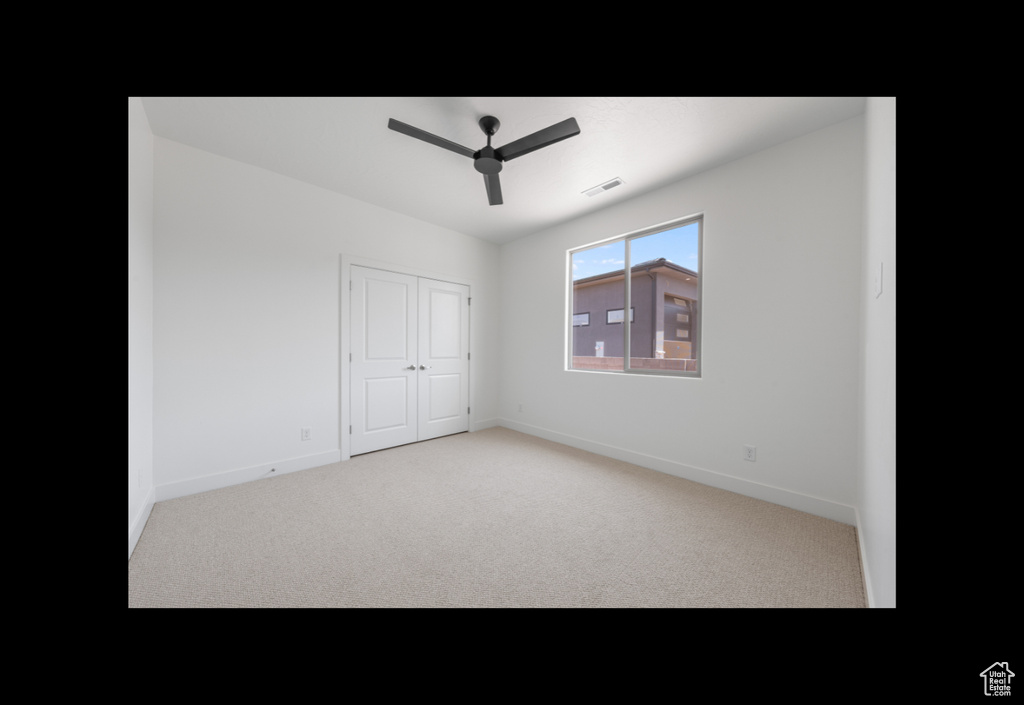 Unfurnished bedroom with carpet flooring, a closet, and a ceiling fan