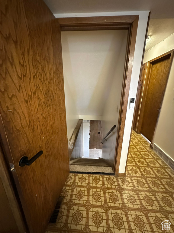 Staircase with tile patterned floors and baseboards
