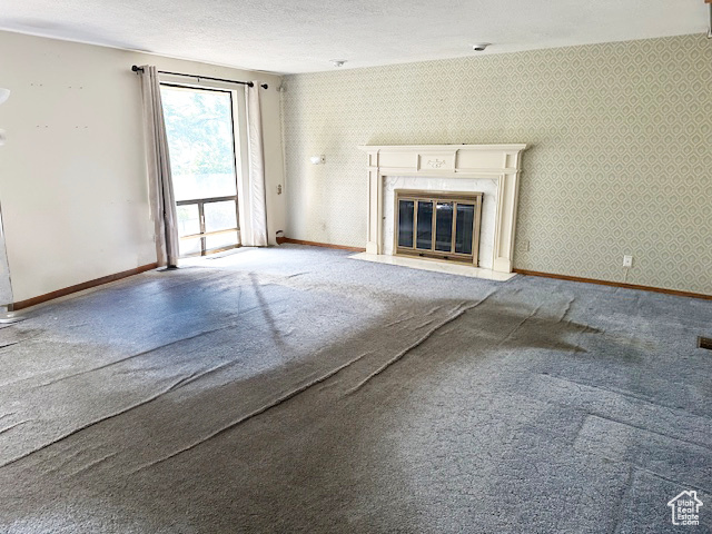 Unfurnished living room featuring a premium fireplace and carpet floors