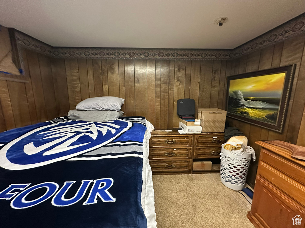 Bedroom featuring carpet flooring and wood walls