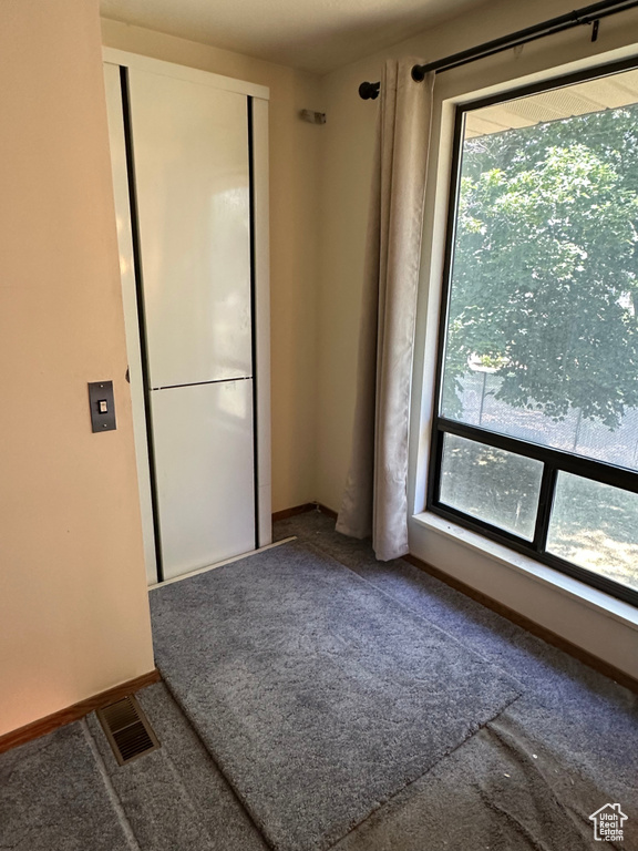 Carpeted spare room featuring baseboards
