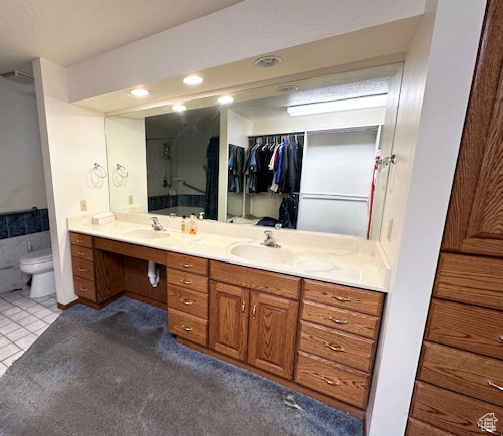 Bathroom with double vanity, tile patterned flooring, a shower, recessed lighting, and a spacious closet