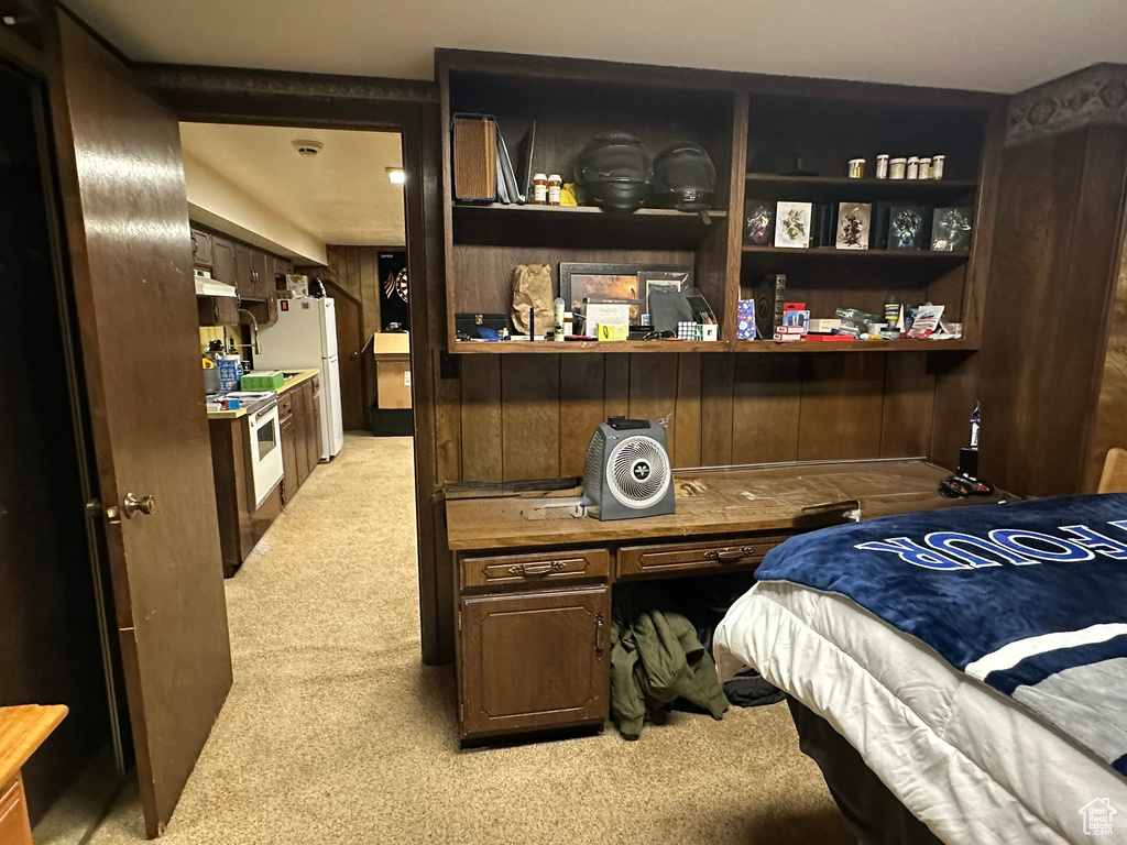 Bedroom with light carpet and freestanding refrigerator
