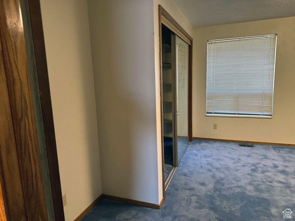Hallway featuring carpet and baseboards