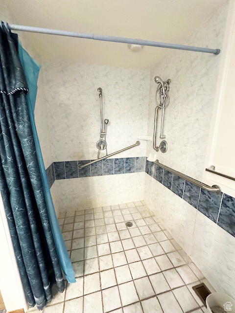Bathroom featuring a tile shower and tile patterned flooring