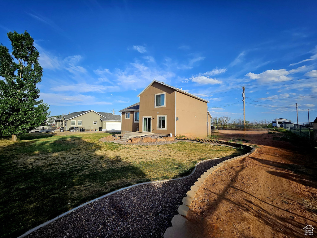 View of side of property with a yard and stucco siding
