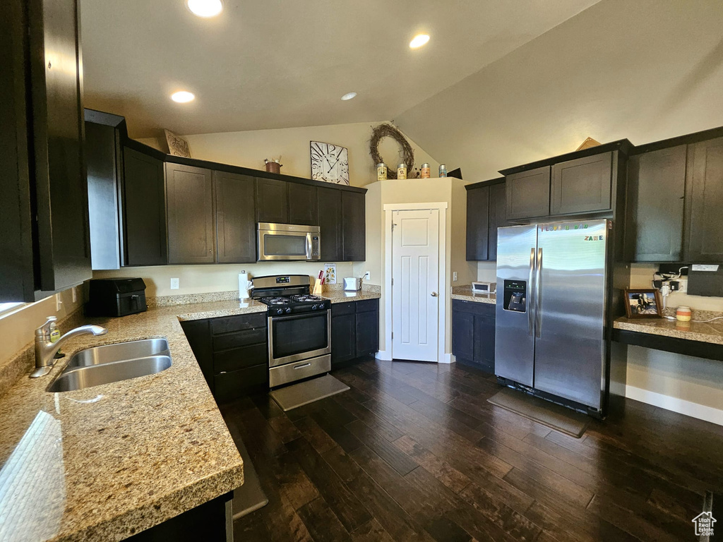 Kitchen with stainless steel appliances, dark wood-type flooring, light countertops, high vaulted ceiling, and recessed lighting