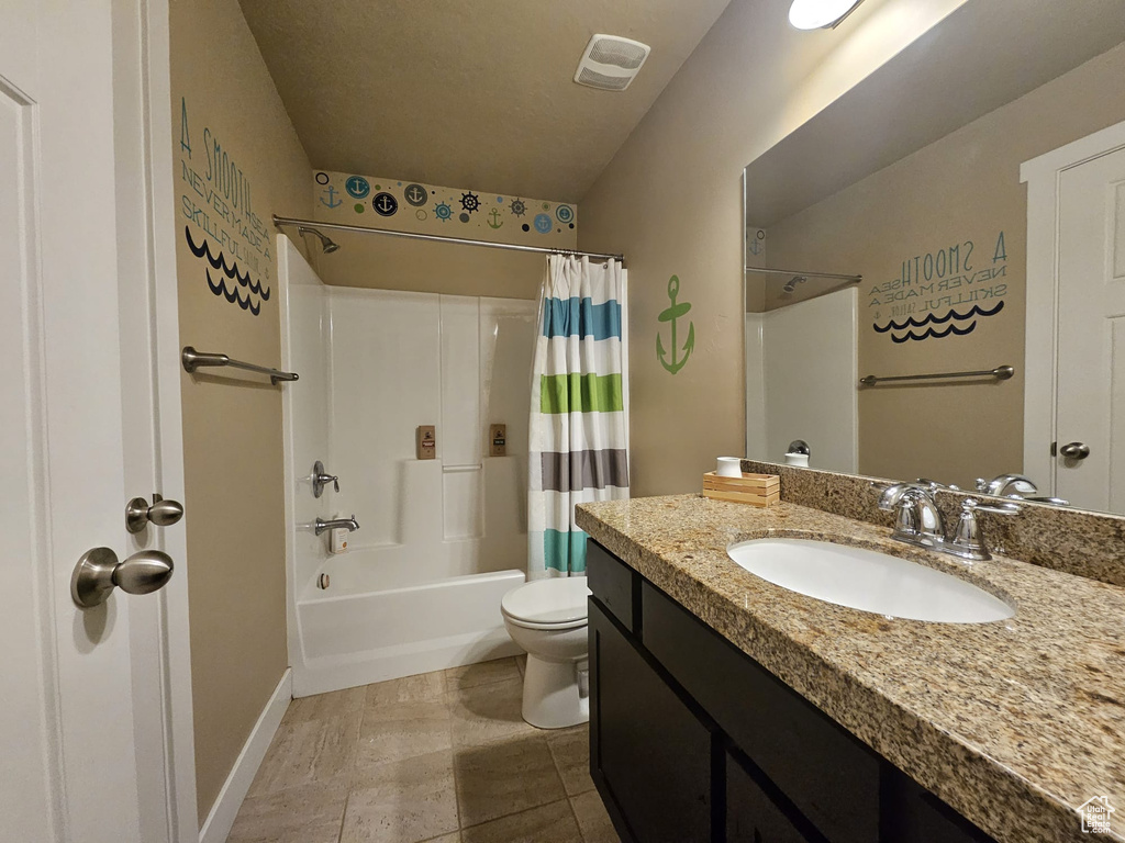 Bathroom with vanity, shower / tub combo, and tile patterned flooring