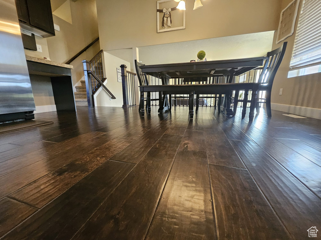 Dining room featuring hardwood / wood-style flooring, a high ceiling, and stairs