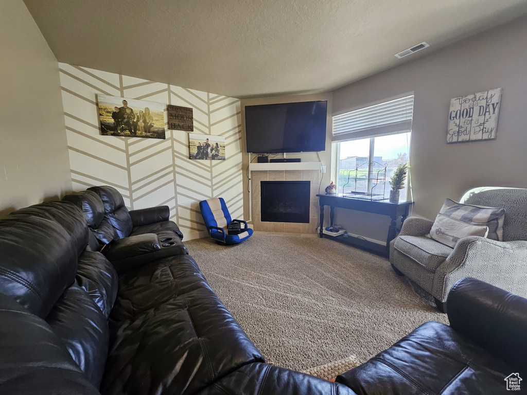 Living area with carpet flooring and a tile fireplace