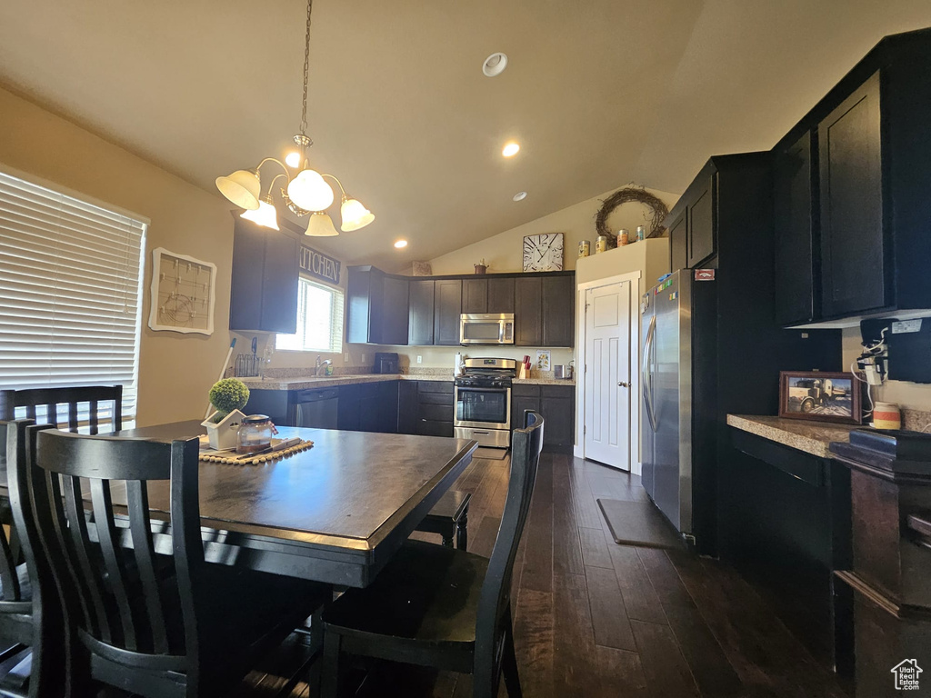 Dining space with a chandelier, dark wood-type flooring, lofted ceiling, and recessed lighting