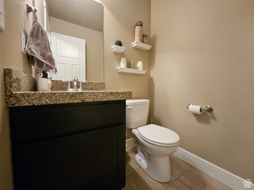Half bathroom with vanity and tile patterned floors