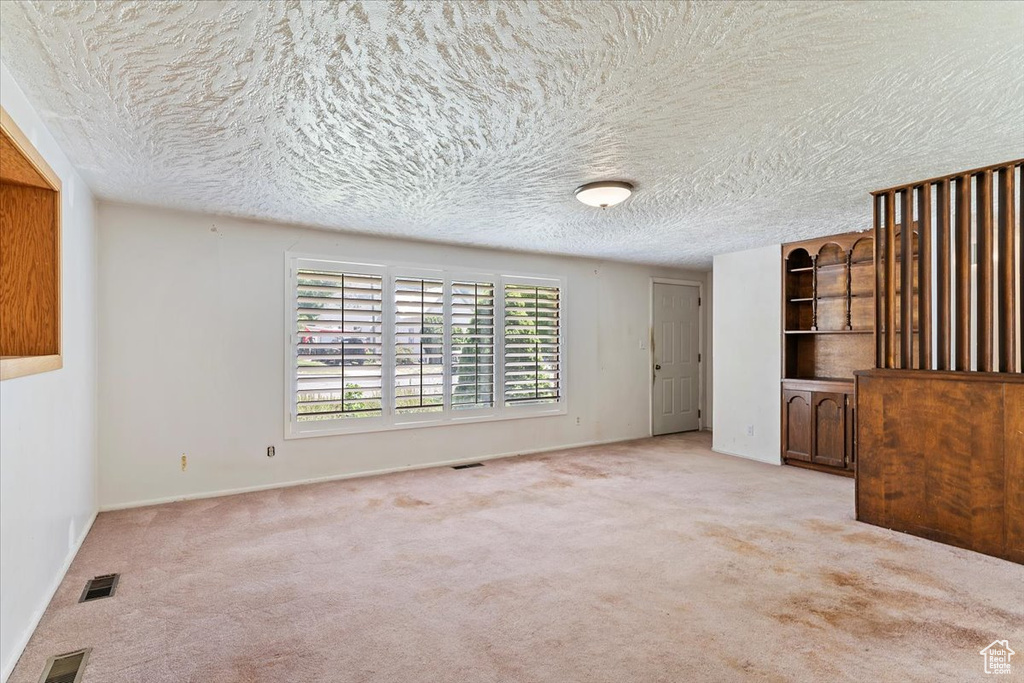 Empty room featuring carpet floors and a textured ceiling