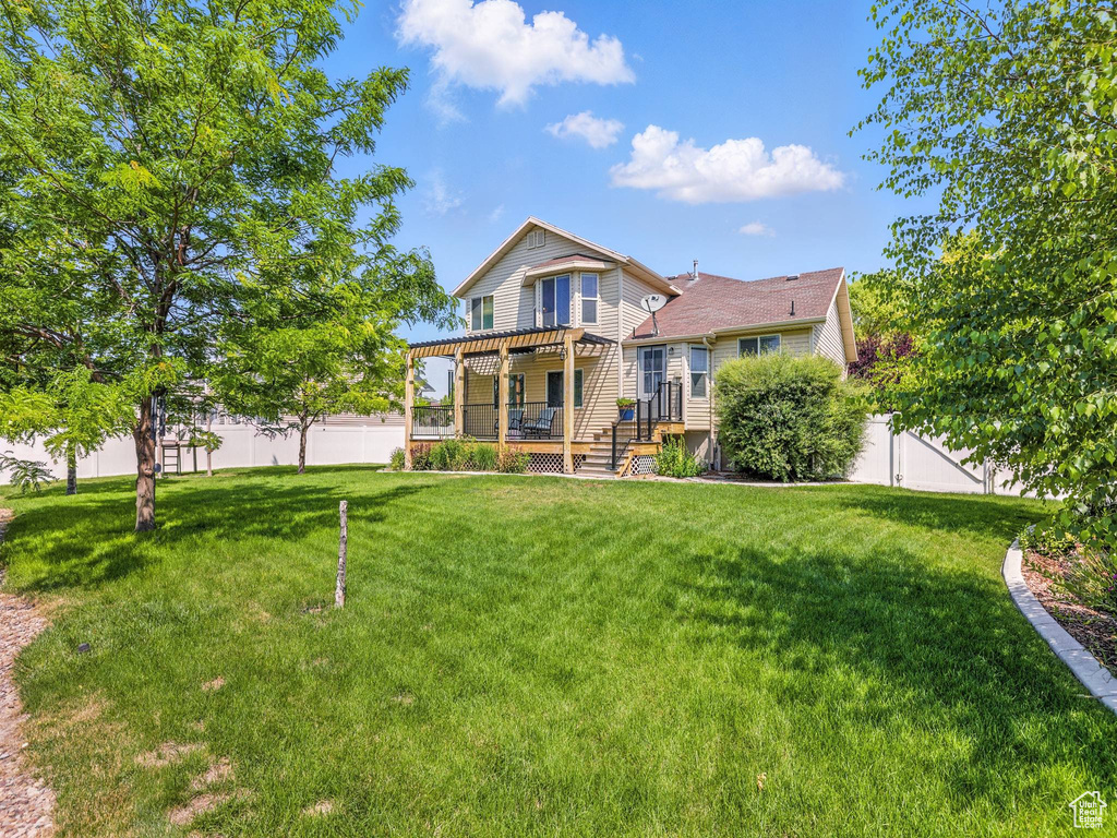 Rear view of property featuring a wooden deck and a fenced backyard