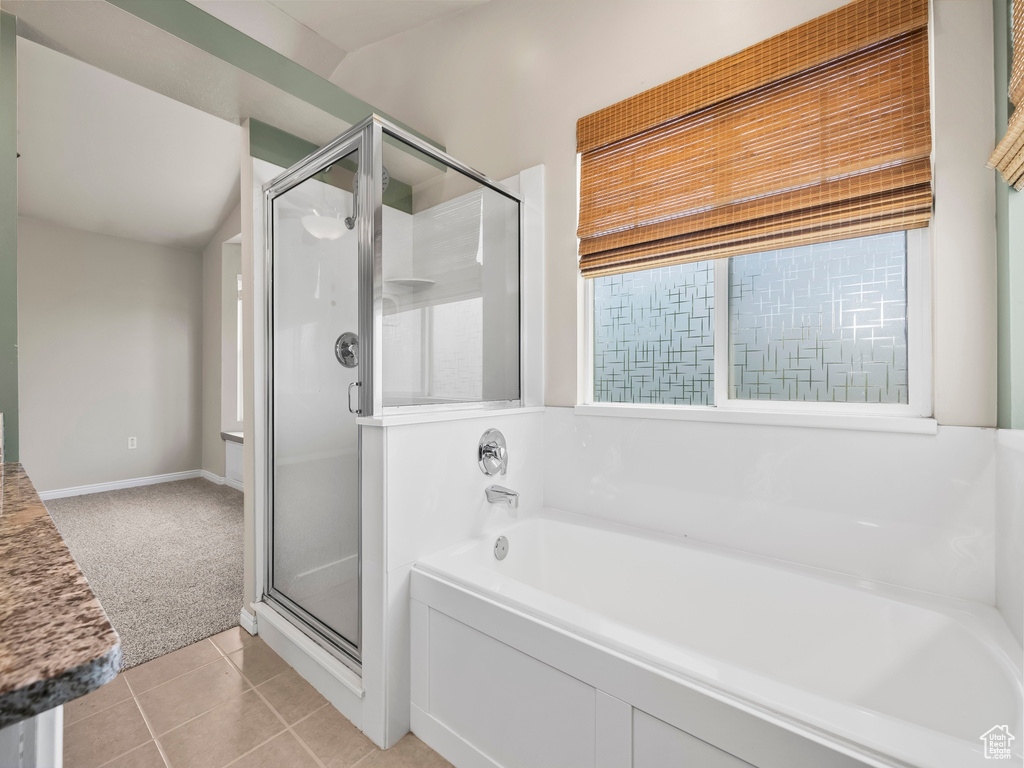 Full bath featuring a stall shower, a garden tub, and tile patterned flooring