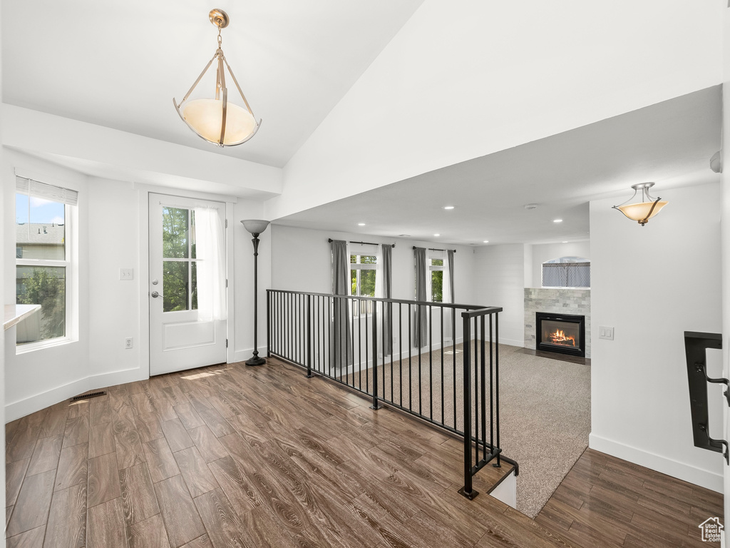 Unfurnished living room featuring wood finished floors, plenty of natural light, a tile fireplace, and recessed lighting