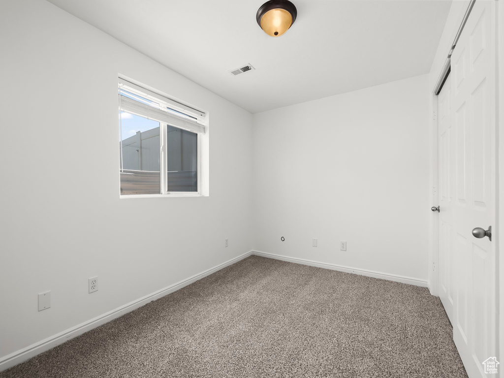 Empty room featuring carpet floors and baseboards