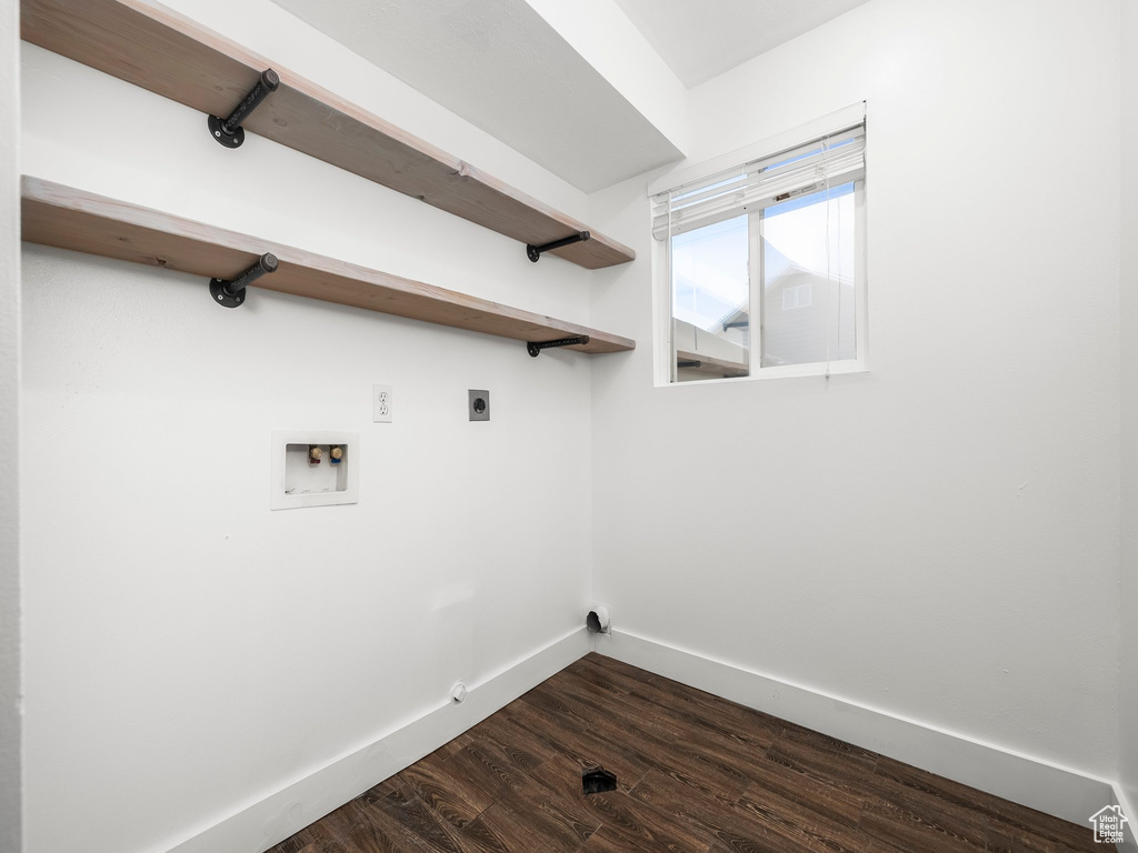Washroom with hookup for a washing machine, hookup for an electric dryer, and dark wood-type flooring