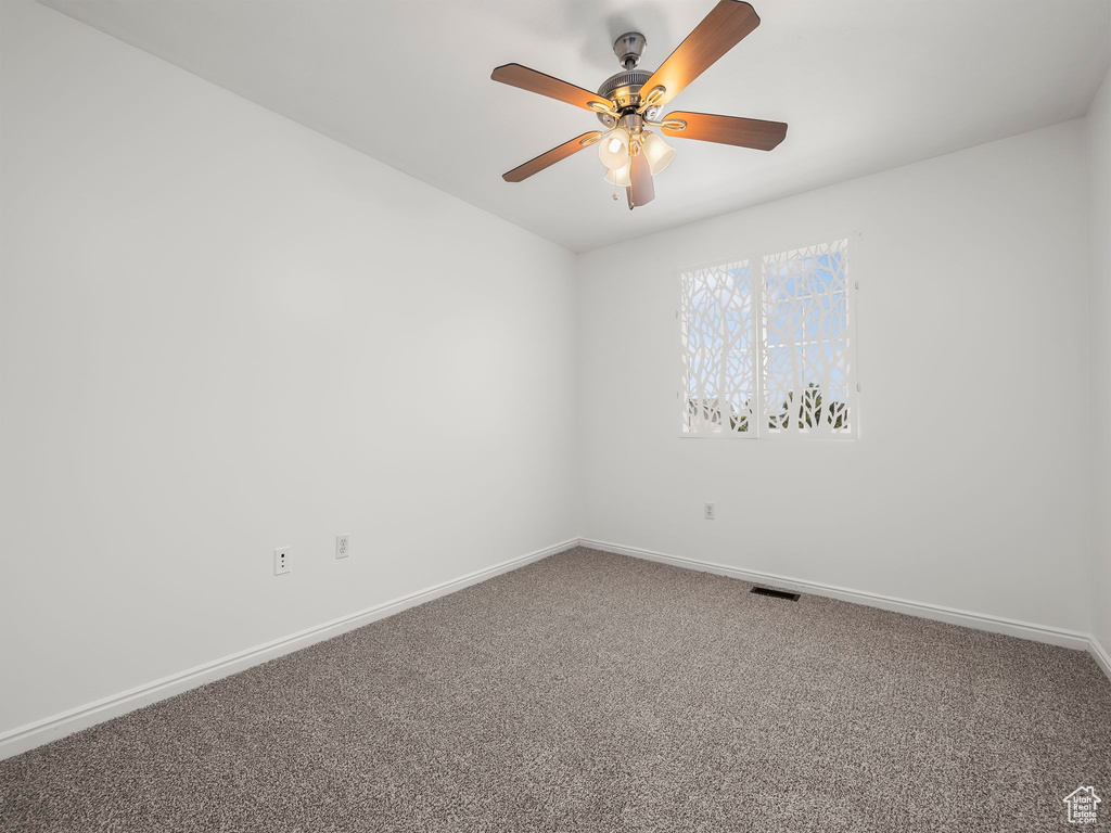 Empty room with carpet and ceiling fan