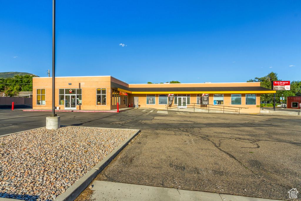 View of building exterior featuring uncovered parking