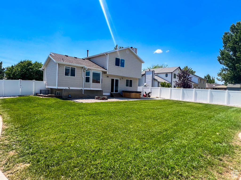 Rear view of house featuring a fenced backyard, entry steps, a patio, and a chimney