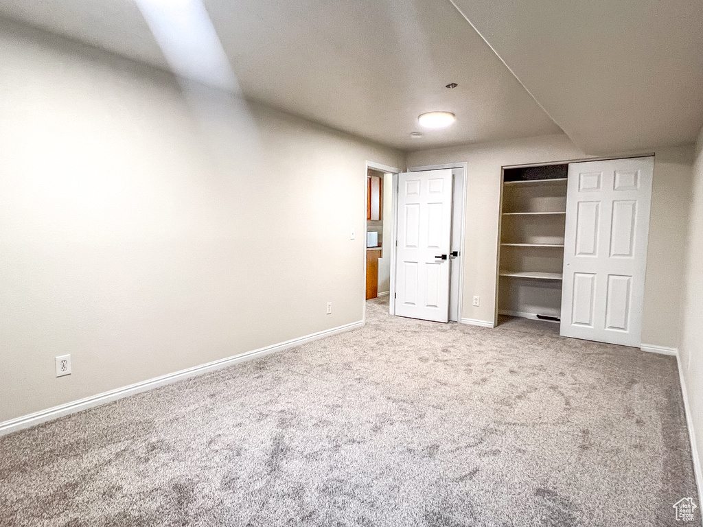 Unfurnished bedroom featuring carpet flooring and a closet