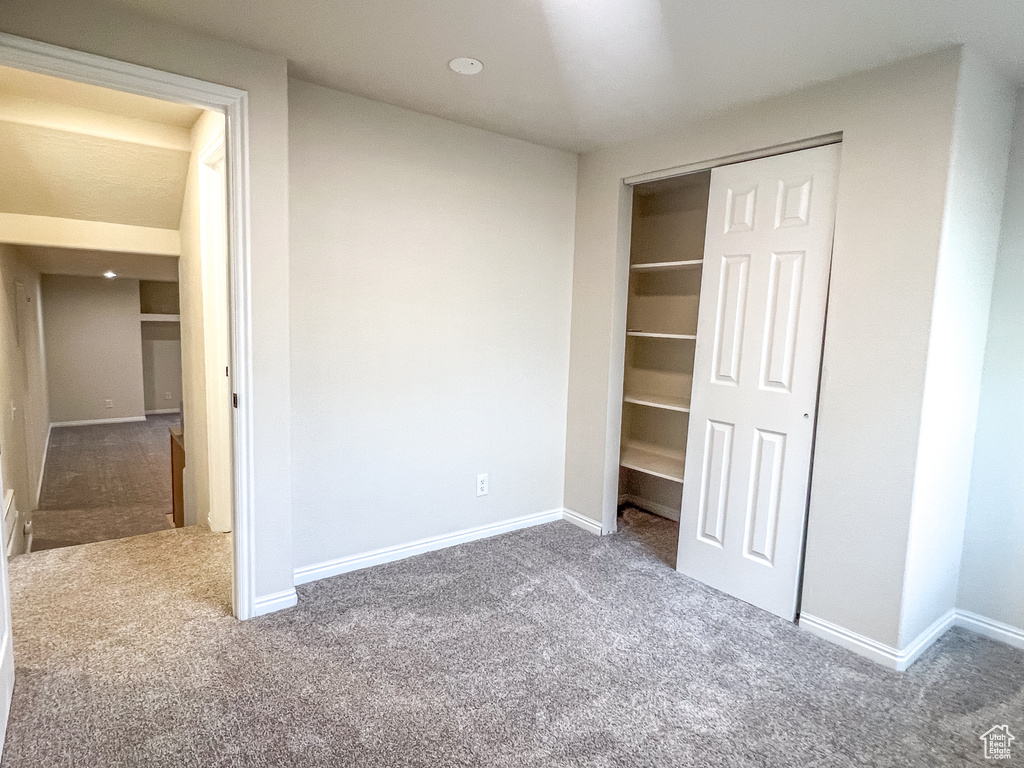Unfurnished bedroom with carpet and a closet