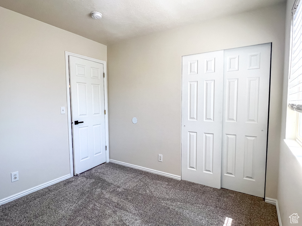 Unfurnished bedroom with carpet and a closet
