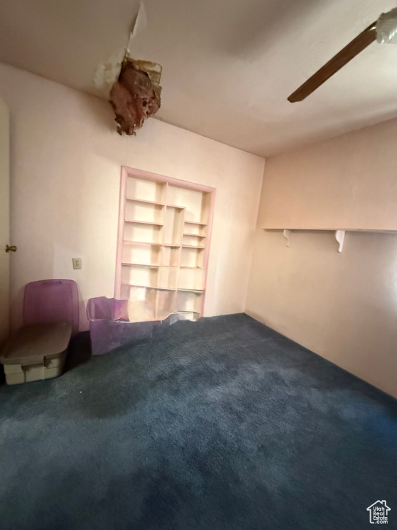 Living room featuring carpet and a ceiling fan