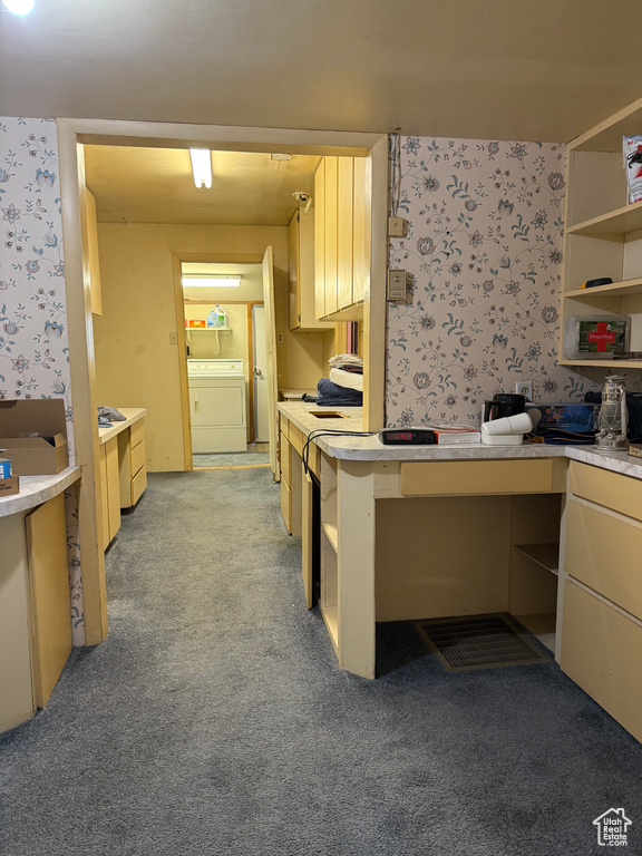 Kitchen with wallpapered walls, light carpet, light countertops, open shelves, and washer and dryer