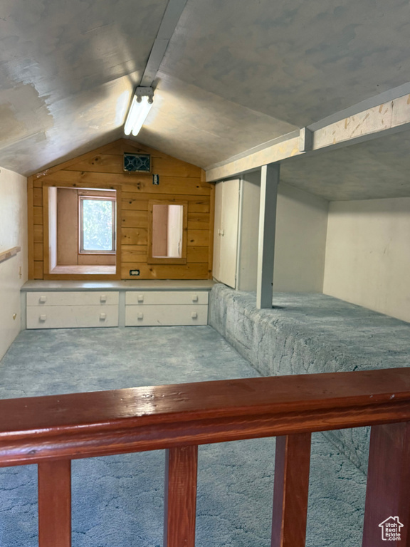 Unfurnished bedroom featuring vaulted ceiling and carpet flooring