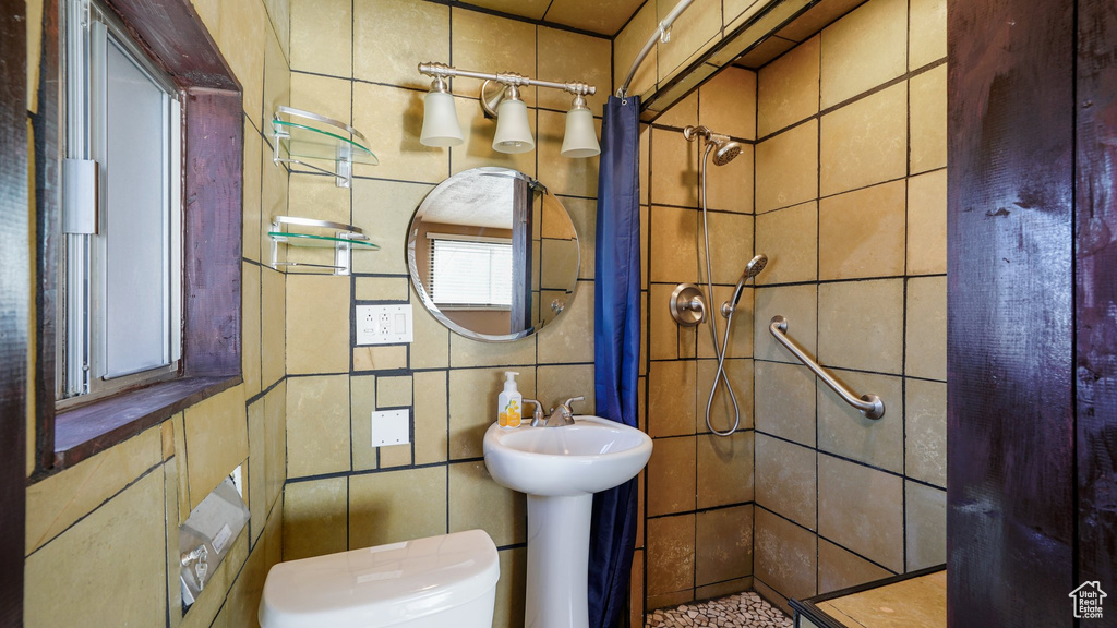 Full bathroom with tile walls and a stall shower