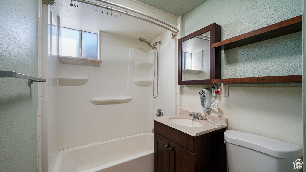 Full bath with vanity, washtub / shower combination, and a textured wall