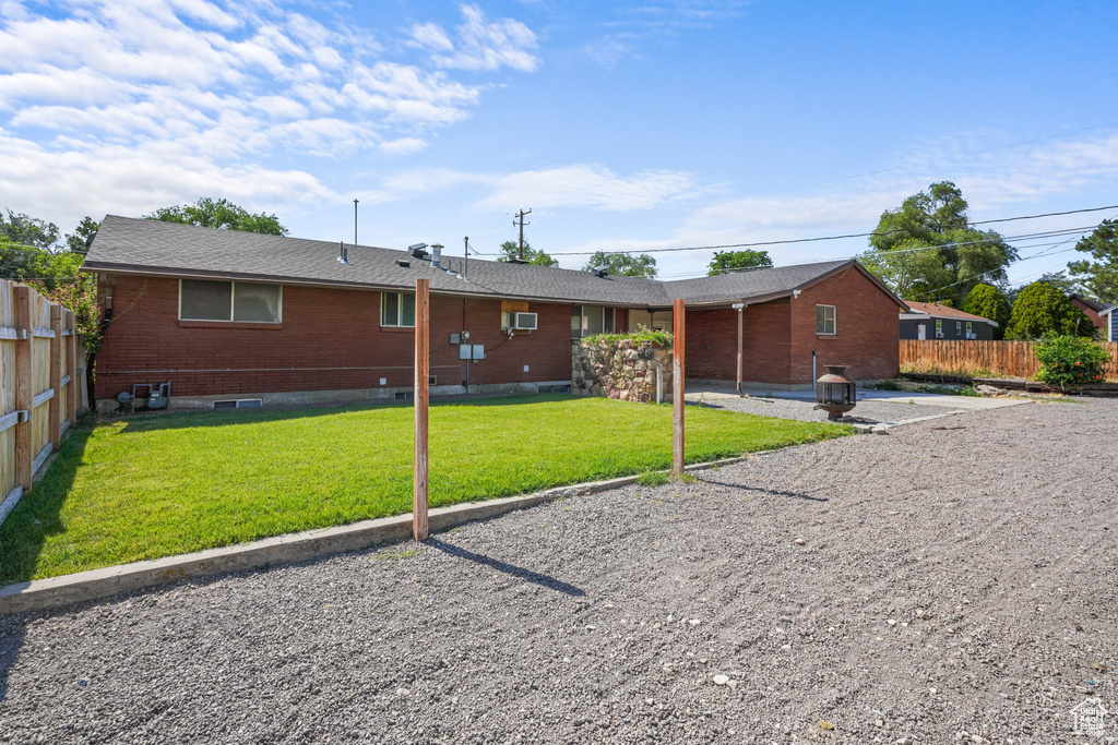 Back of house featuring brick siding and a wall unit AC