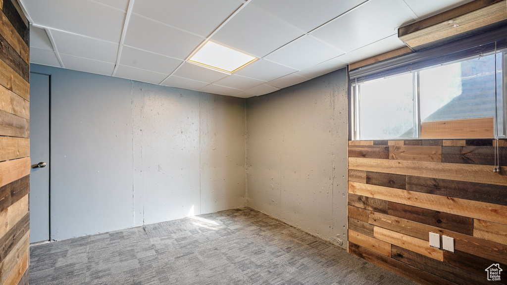 Carpeted empty room featuring a paneled ceiling