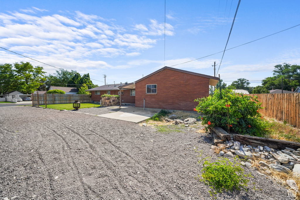 View of side of home with brick siding and a patio area