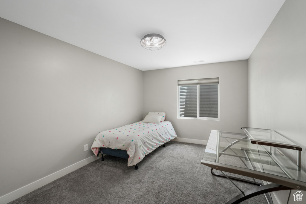 Bedroom featuring baseboards and carpet