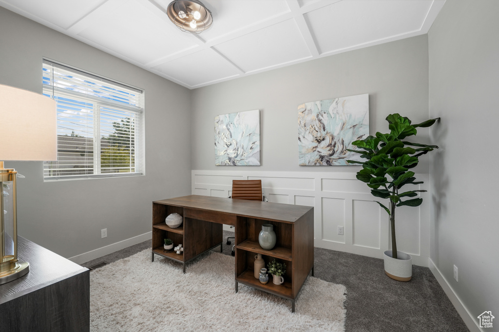 Home office with carpet floors, coffered ceiling, wainscoting, and a decorative wall