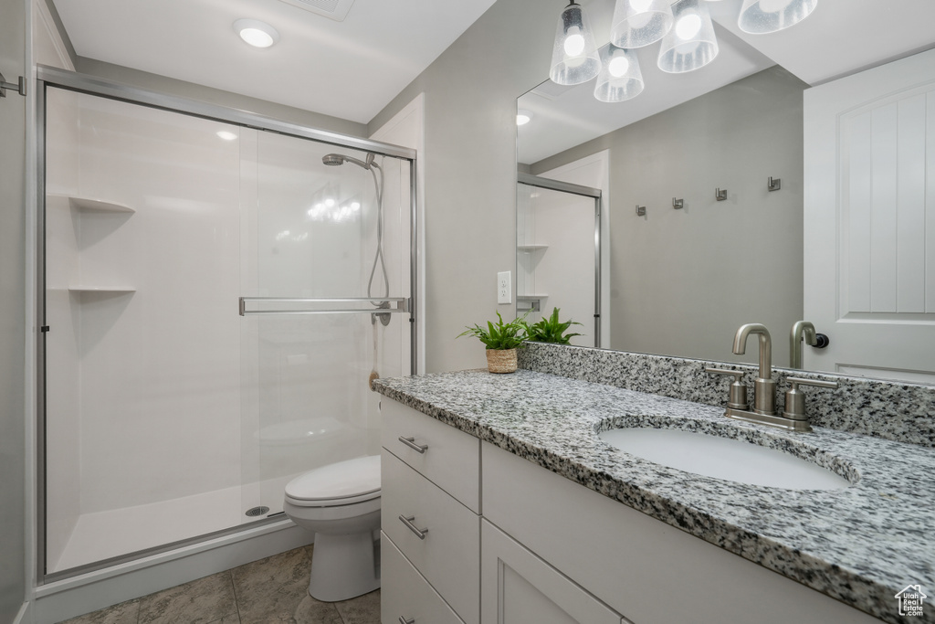 Full bath featuring vanity, a stall shower, and tile patterned flooring