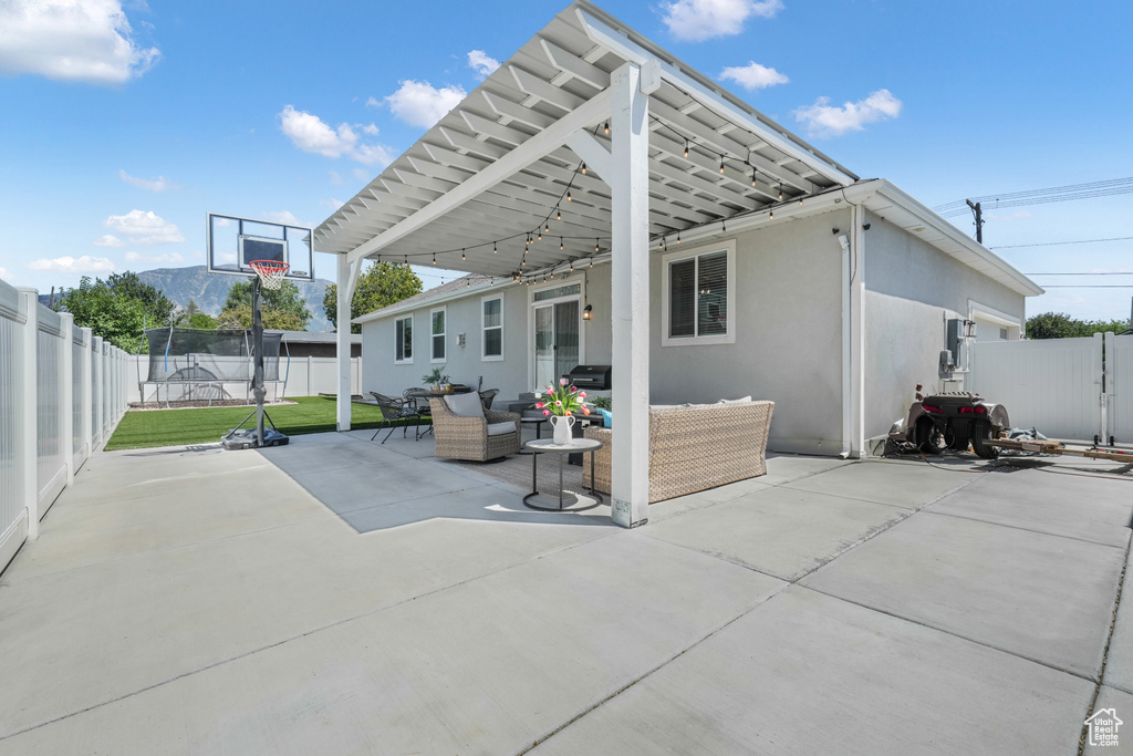 Rear view of property with stucco siding, an outdoor living space, a fenced backyard, and a patio