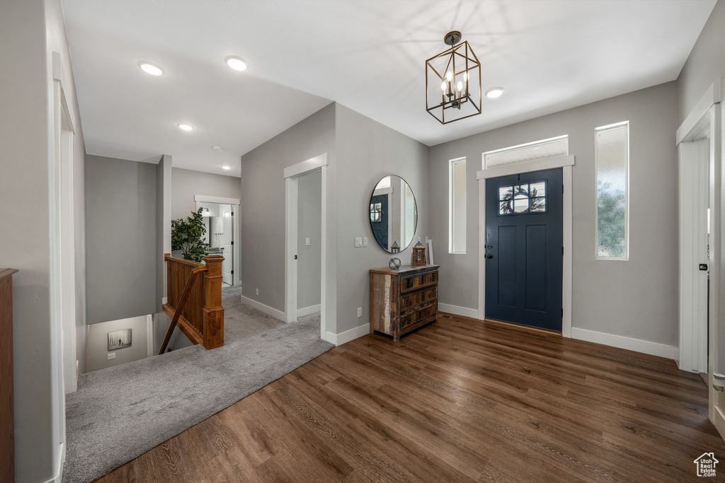 Foyer entrance with wood finished floors, a chandelier, and recessed lighting