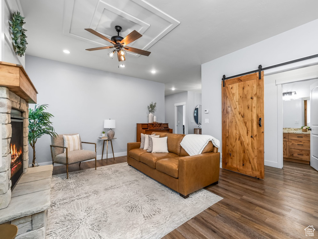 Living area featuring a ceiling fan, dark wood-style floors, a fireplace, recessed lighting, and a barn door