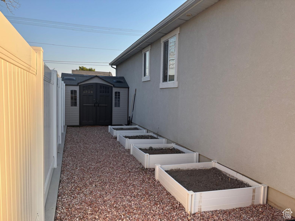 View of yard featuring a garden and a shed