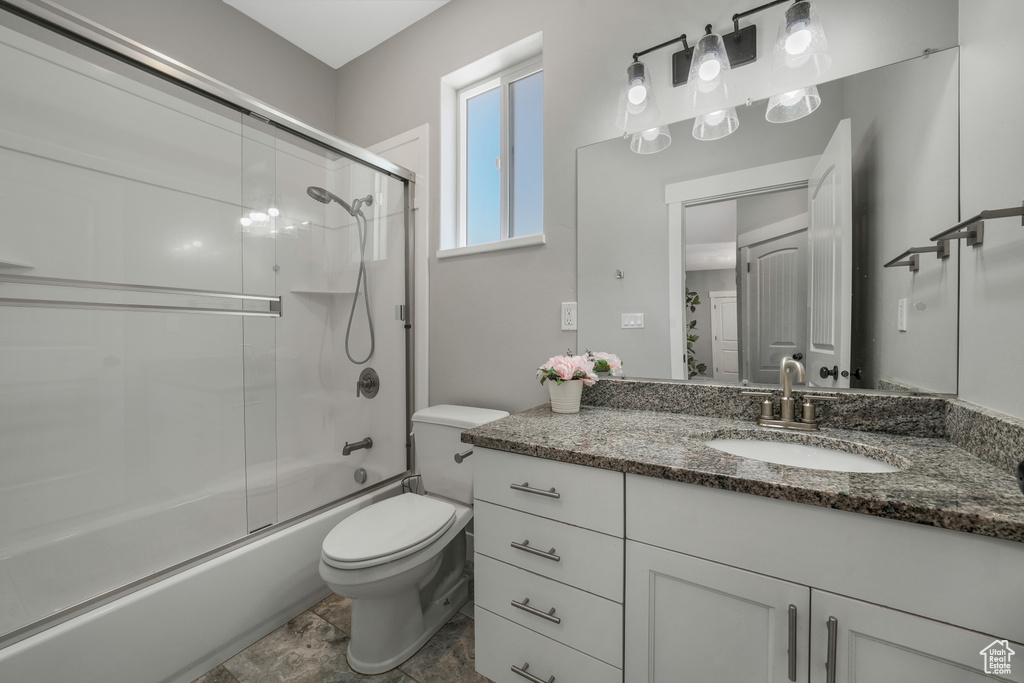 Bathroom with vanity and enclosed tub / shower combo