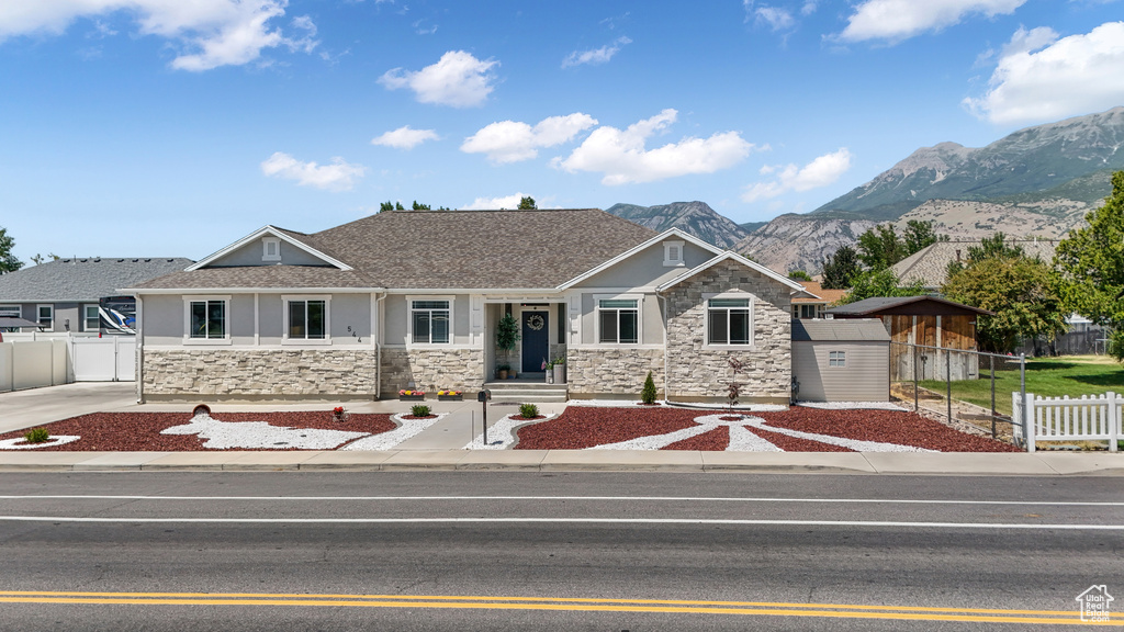 Craftsman inspired home featuring stone siding, a mountain view, stucco siding, and a storage unit