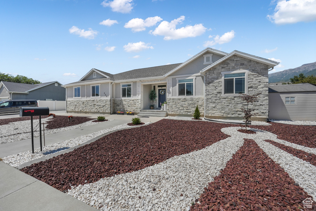 View of front of property with stone siding, stucco siding, and a mountain view