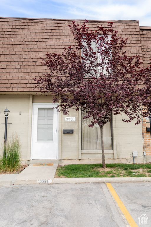 Entrance to property featuring uncovered parking and brick siding